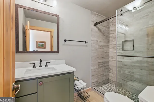 a bathroom with a sink toilet a mirror and shower