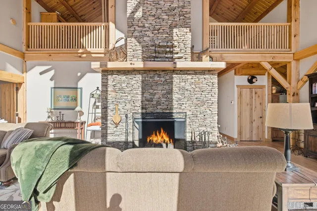 a living room with furniture a fireplace and a floor to ceiling window