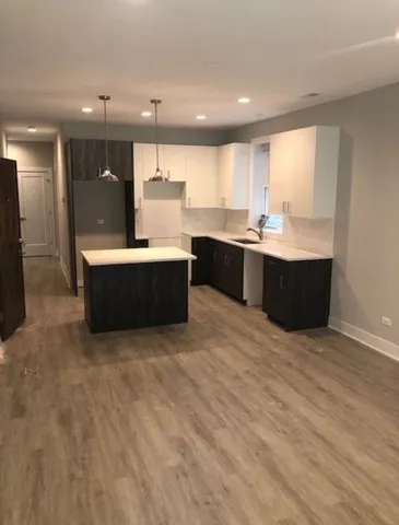 a large kitchen with kitchen island a sink stainless steel appliances and cabinets