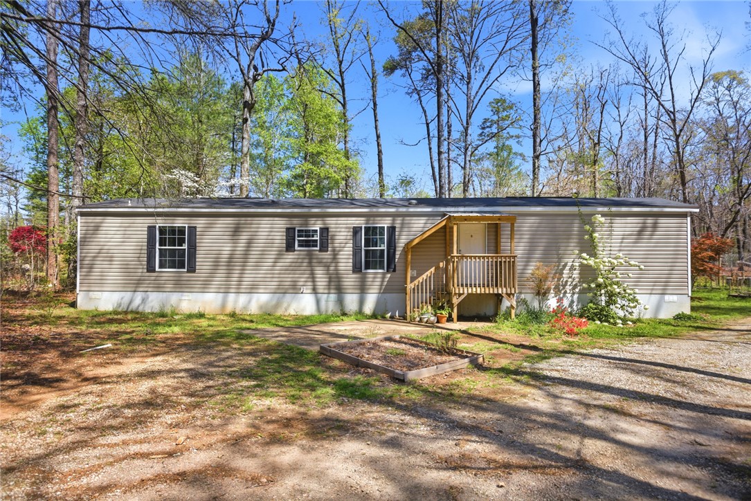 289 Bauknight Road Mountain Rest, SC 29664 - Photo 1 of 1 This residence features a welcoming wooden porch, surrounded by lush, vibrant greenery.