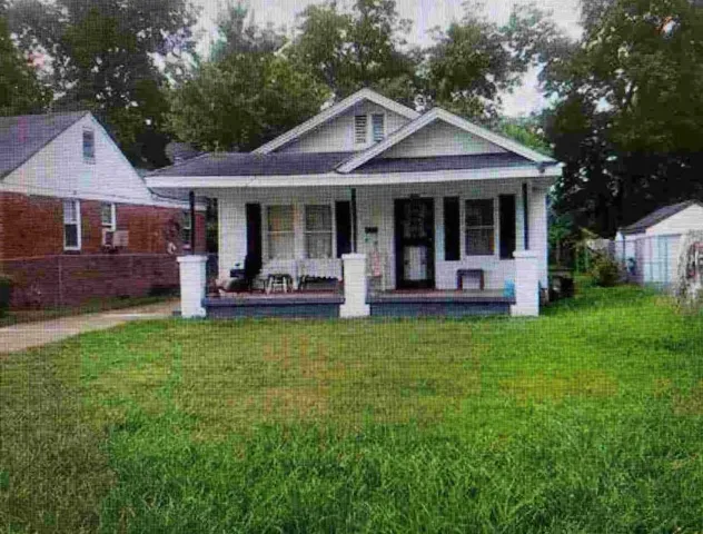 a front view of a house with a yard garden and patio