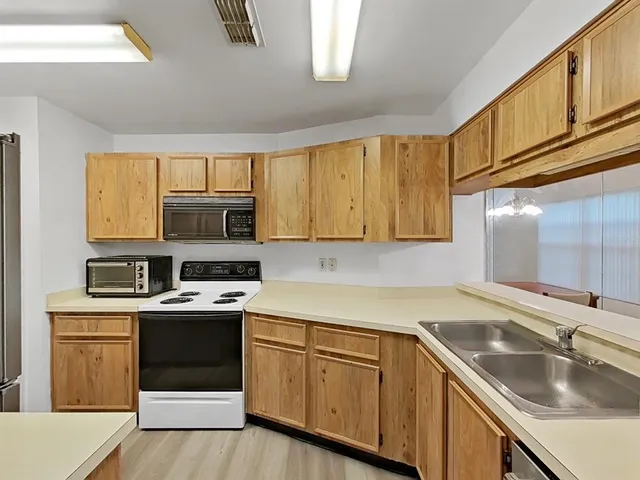 a kitchen with stainless steel appliances granite countertop a sink stove and microwave
