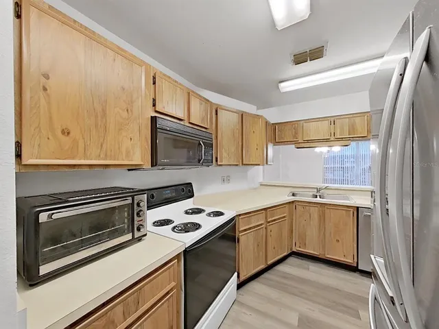 a kitchen with wooden cabinets and white appliances