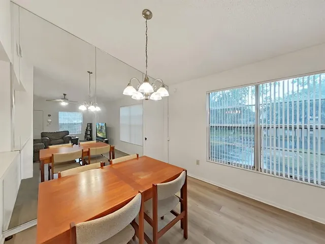 a room with stainless steel appliances kitchen island a table and chairs in it