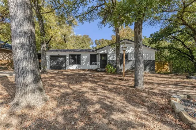 a front view of a house with a tree