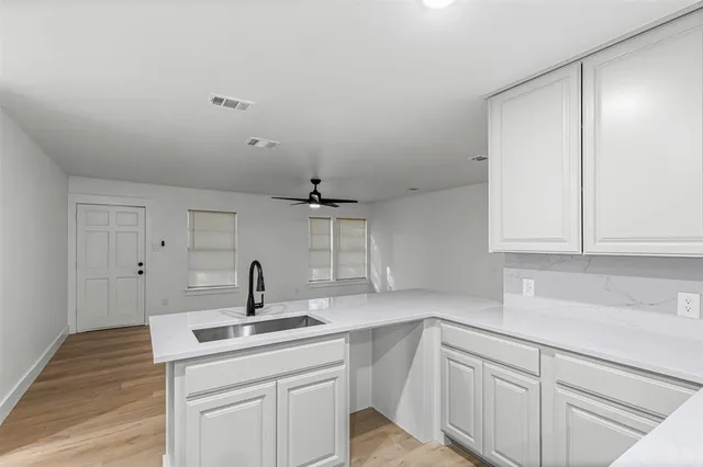 a kitchen with white cabinets stainless steel appliances and sink