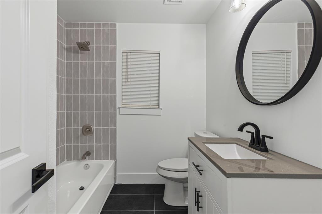1509 Shirley Way Bedford, TX 76022 - Photo 14 of 26 Full bath with dark tile patterned floors, vanity, and tub / shower combination