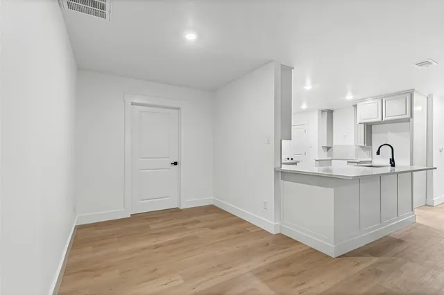 an empty room with wooden floor ceiling fan and windows