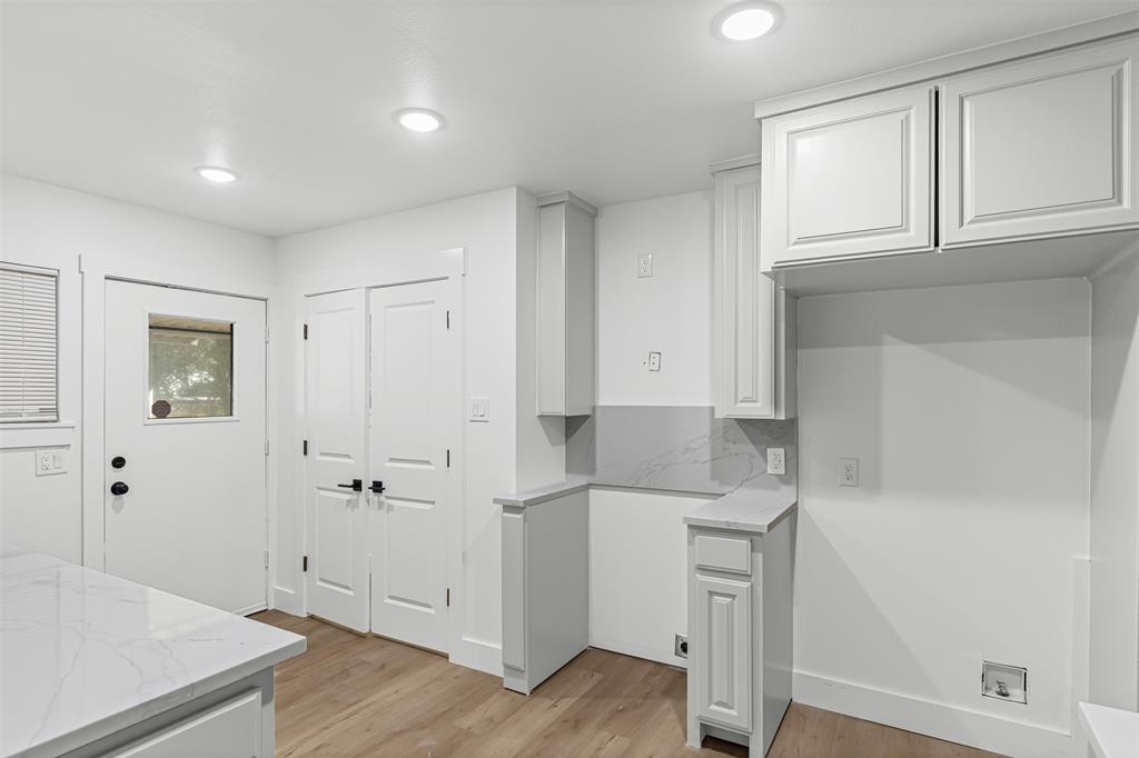 1509 Shirley Way Bedford, TX 76022 - Photo 9 of 26 Kitchen featuring white cabinetry, light wood-style floors, light stone counters, recessed lighting, and tasteful backsplash