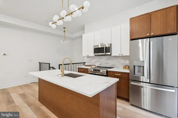 a kitchen with stainless steel appliances chandelier a refrigerator and a stove