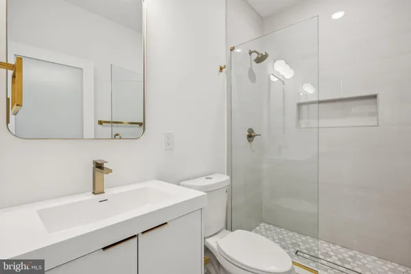 a bathroom with a sink a toilet and shower
