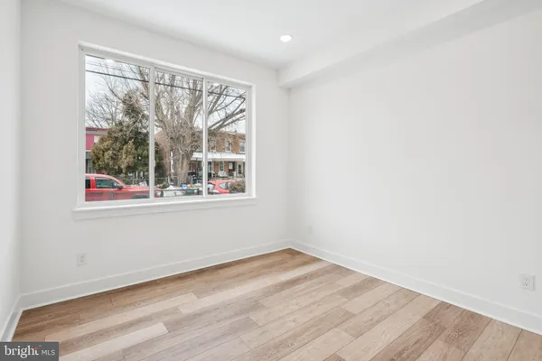 an empty room with wooden floor and a window