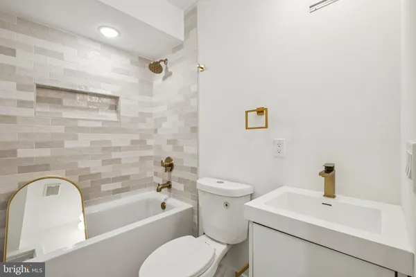 a white toilet sitting next to a bath tub