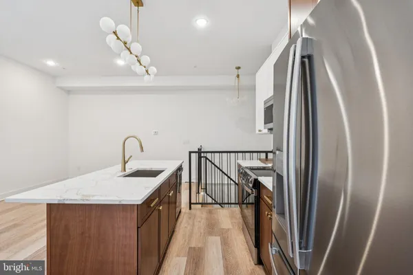 a kitchen with a sink a refrigerator and wooden floor