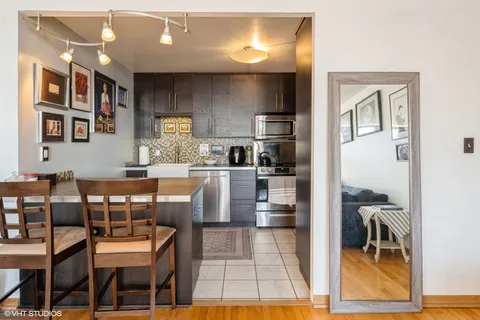 a kitchen with stainless steel appliances kitchen island granite countertop a refrigerator and cabinets