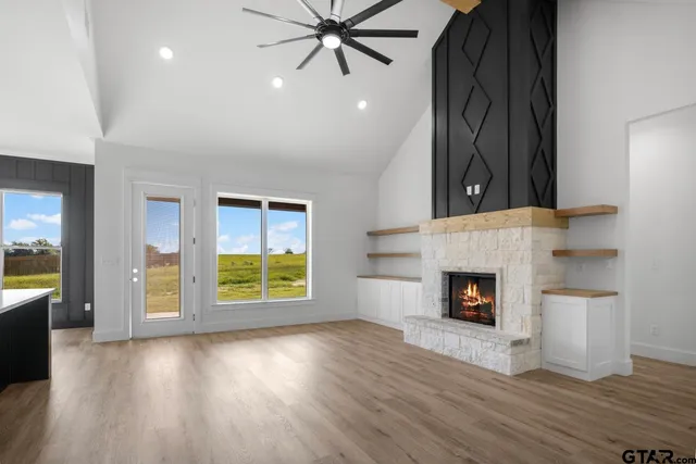 an empty room with windows and fireplace