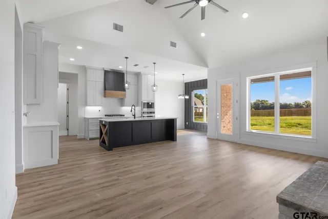 a view of kitchen with kitchen island a sink stainless steel appliances and cabinets