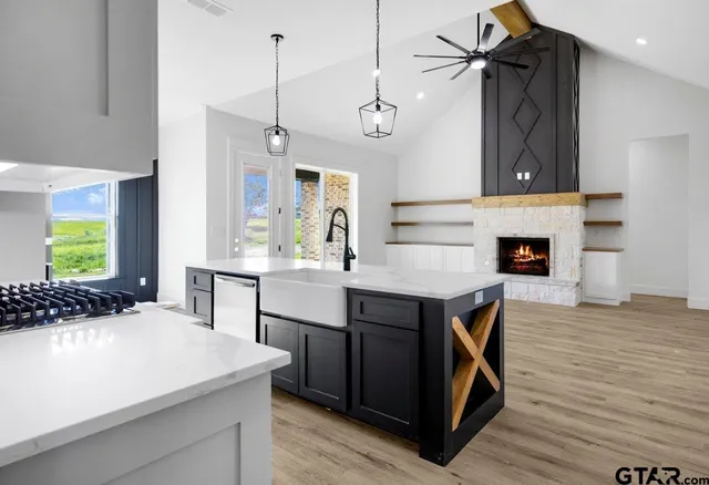 a kitchen with kitchen island a wooden floor and a refrigerator