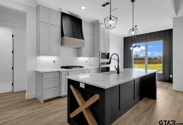 a kitchen with a sink cabinets and wooden floor