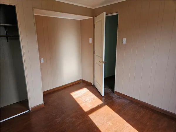 an empty room with wooden floor and closet