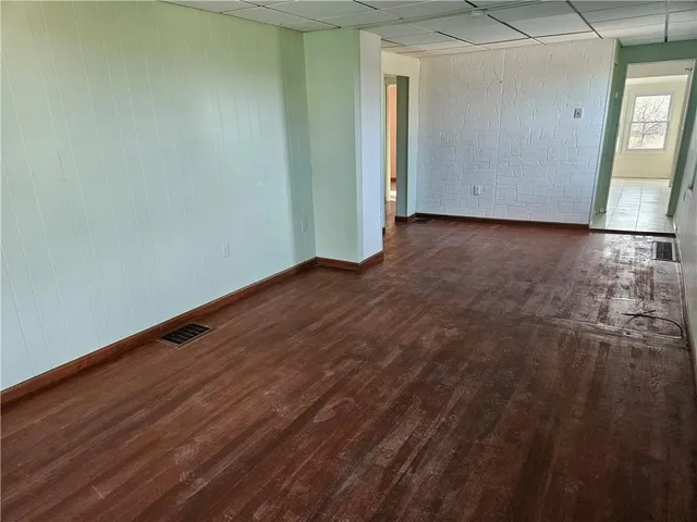 a view of an empty room with window and wooden floor