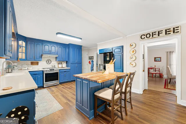 a kitchen with stainless steel appliances kitchen island granite countertop a stove a sink and a refrigerator