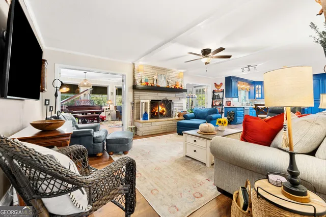 a living room with furniture a flat screen tv and kitchen view