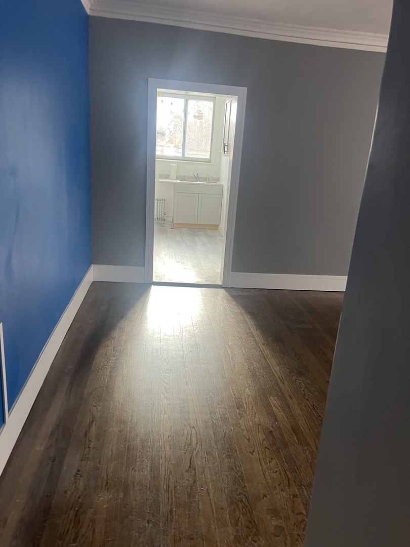 1825 East 79th Street, Unit 2R Chicago, IL 60649 - Photo 2 of 8 an empty room with wooden floor and windows