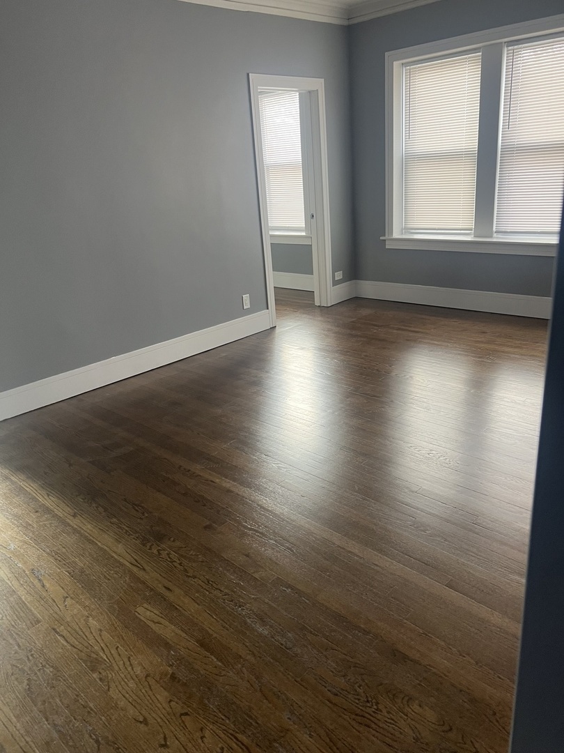 1825 East 79th Street, Unit 2R Chicago, IL 60649 - Photo 4 of 8 an empty room with wooden floor and windows