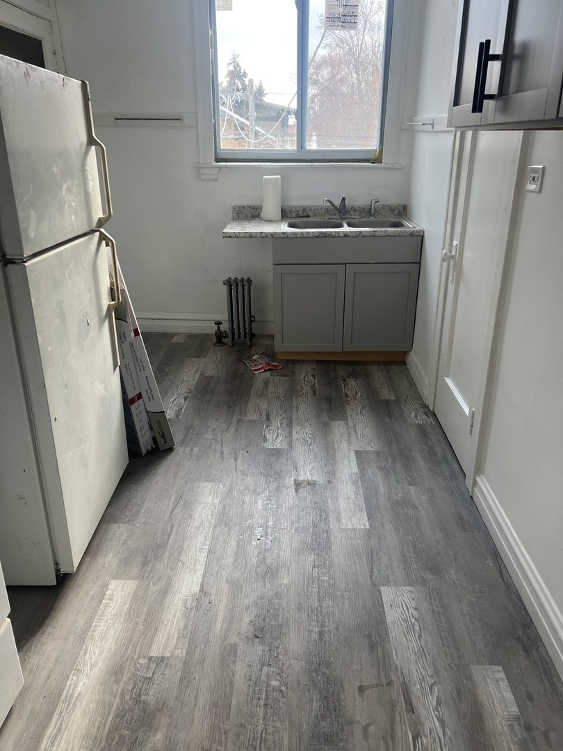 1825 East 79th Street, Unit 2R Chicago, IL 60649 - Photo 8 of 8 a room with wooden floors and sink