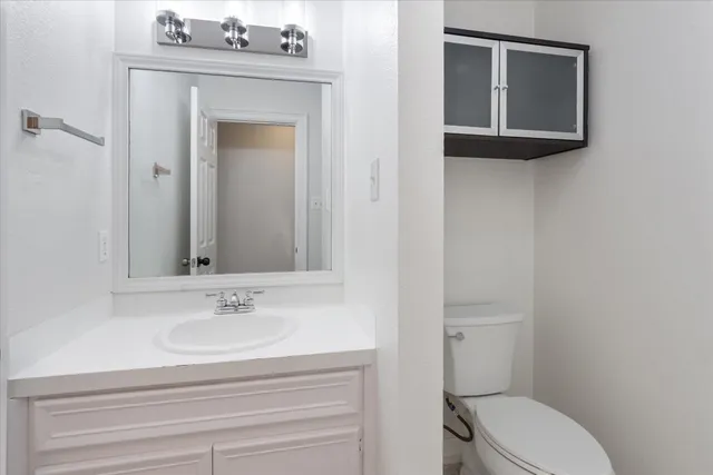 a bathroom with a sink mirror and toilet