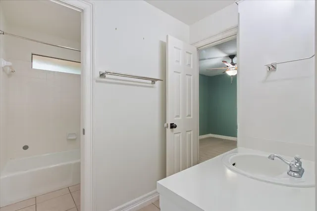 a bathroom with a tub a sink and mirror