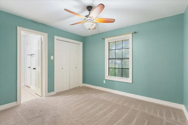 an empty room with fan and windows
