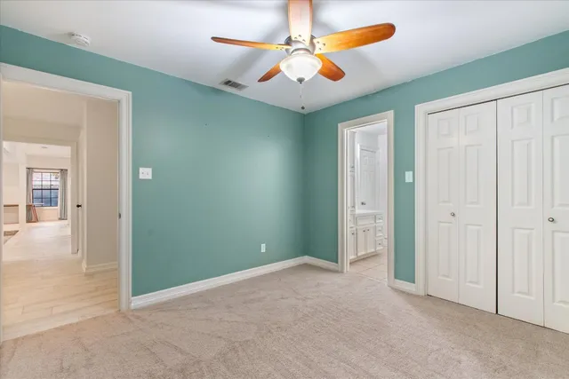 an empty room with closet and fan