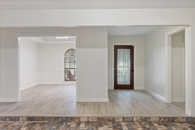 a view of a hallway with wooden floor and glass door