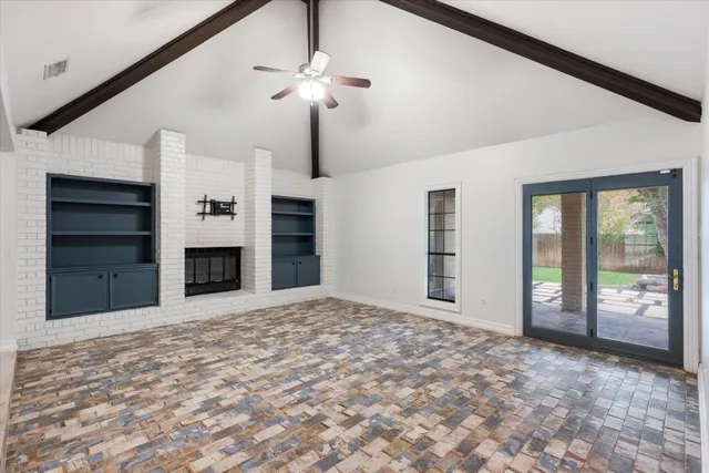 a view of an empty room with a fireplace and a window