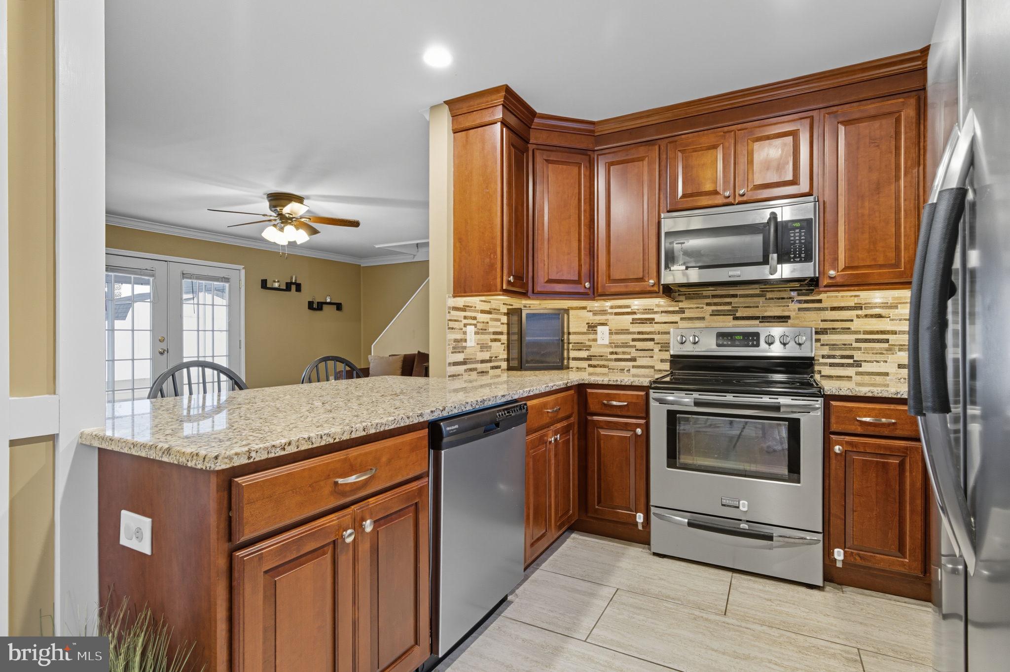 9 Newberry Lane Levittown, PA 19054 - Photo 5 of 36 a kitchen with stainless steel appliances granite countertop a stove microwave and sink