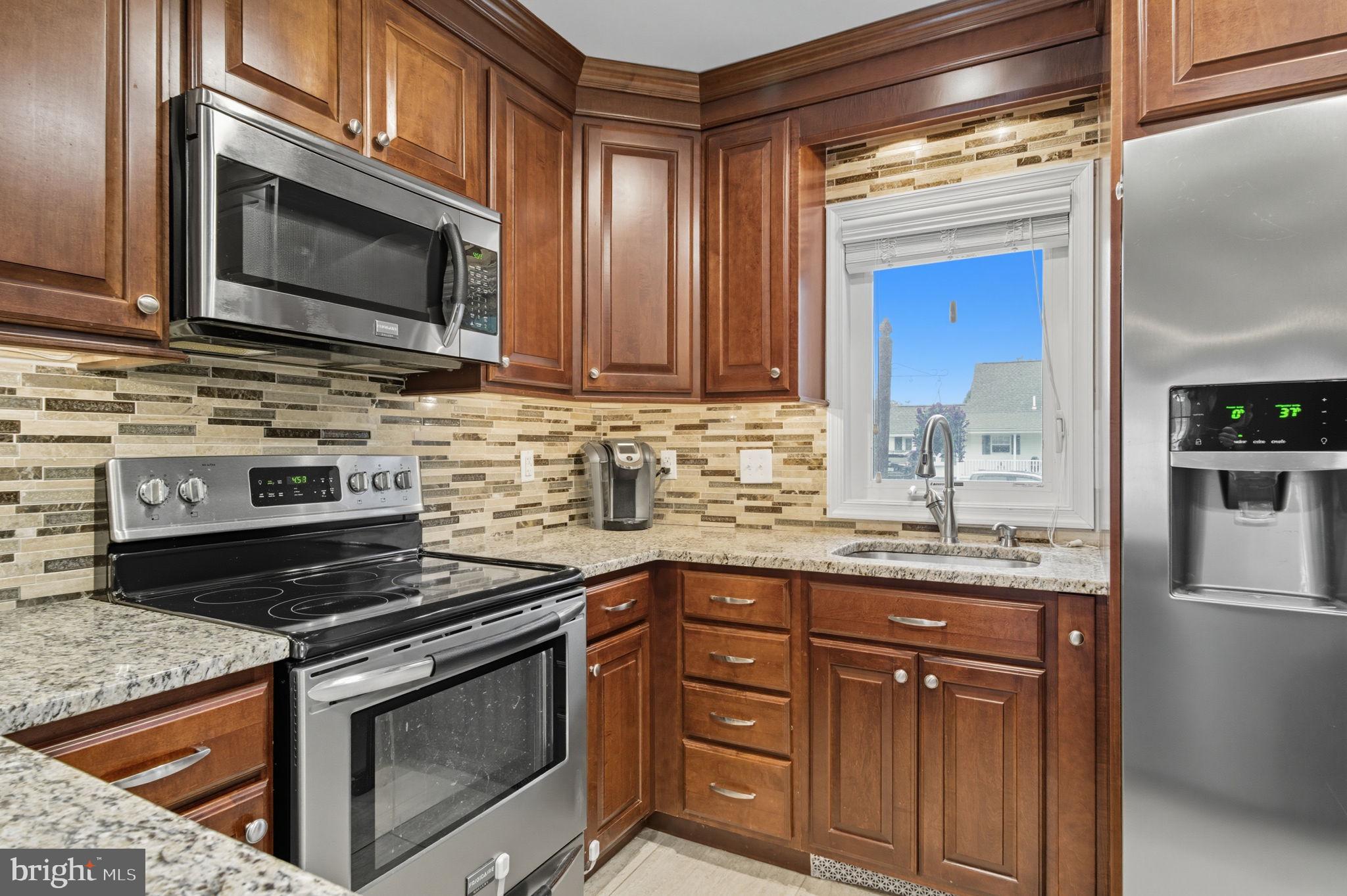 9 Newberry Lane Levittown, PA 19054 - Photo 6 of 36 a kitchen with stainless steel appliances granite countertop a stove microwave and cabinets
