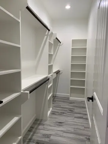 a view of walk in closet with empty racks