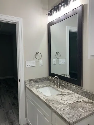 a bathroom with a granite countertop sink and a mirror