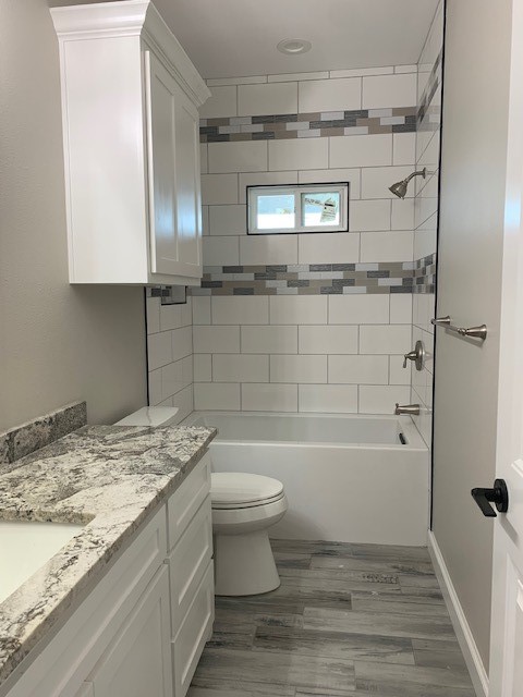 592 West Garrett Street Robstown, TX 78380 - Photo 14 of 15 a bathroom with a granite countertop sink a toilet and bathtub