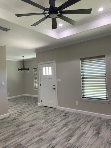 a view of an empty room and window and wooden floor