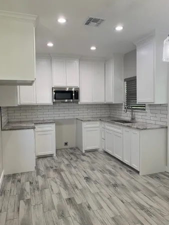 a kitchen with granite countertop a sink and cabinets