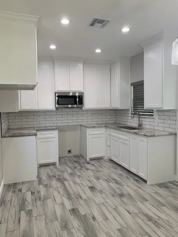 a kitchen with granite countertop a sink and cabinets