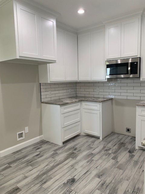 592 West Garrett Street Robstown, TX 78380 - Photo 8 of 15 a kitchen with stainless steel appliances granite countertop a stove a sink and white cabinets