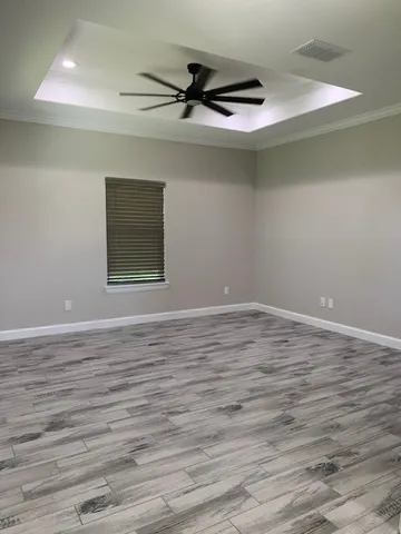 a view of a livingroom with wooden floor and a ceiling fan