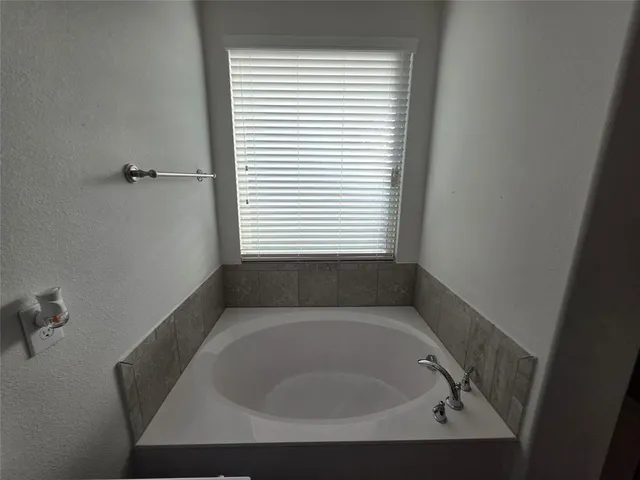 a bath tub sitting in a bathroom next to a window