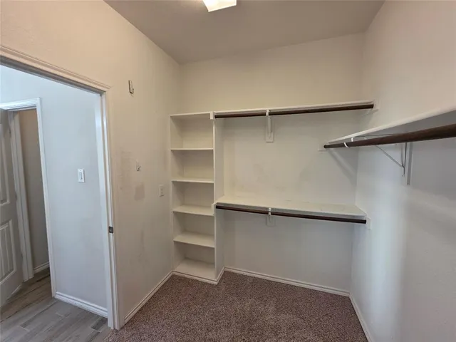 a view of walk in closet with empty racks