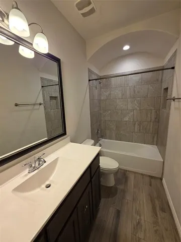 a bathroom with a sink a toilet a mirror and bathtub