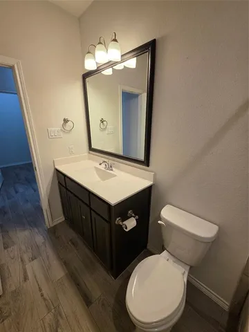 a bathroom with a toilet a sink and mirror